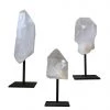 A Modern Grand Tour Curiosities Set Of Three Clear Quartz Crystals Mounted On Black Metal Stands