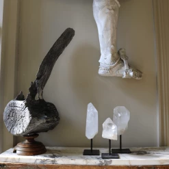 A Modern Grand Tour Curiosities Set Of Three Clear Quartz Crystals Mounted On Black Metal Stands